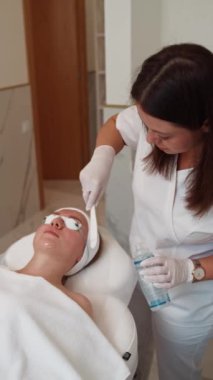 Profesyonel Klinikte Pigmentasyon Kırışıklıklarını ve Vasküler İzleri Çıkarmak İçin Hasta Yüzüne Cilt Tedavisi İçin Kozmetolog Kremi Uyguladı. Yüksek kalite 4k görüntü