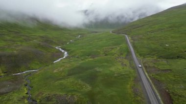 İzlanda Havacılık Manzarası 'nın dağlarında güzel bir sinematik yol. Doğanın manzarası ve Kuzey Kutup Dairesi 'nin arkasındaki yolda giden bir araba. Yüksek kalite 4k görüntü