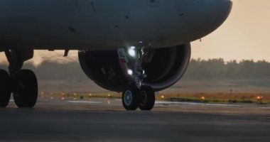 Sunset Showcasing Havacılık ve Havalimanı Seyahat Deneyimi 'ndeki Uçak Tekerlekleri ve Motoru' nun detaylı görüntüsü. Yüksek kalite 4k görüntü
