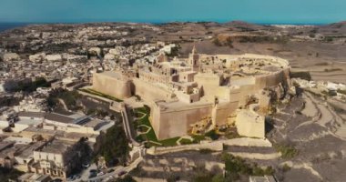 Gozo Adası Malta 'daki Rabat Victoria Kalesi' nin destansı hava görüntülerinde Ortaçağ Kalesi ve Çarpıcı Akdeniz Şehir Manzarası yer alıyor. Yüksek kalite 4k görüntü