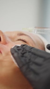 Güzellik uzmanının bir kadına yaptığı güzellik enjeksiyonunun yakın çekimi. Kozmetolojide hastaların ciltlerinin kaldırılması ve tazelenmesi. Yüksek kalite 4k görüntü