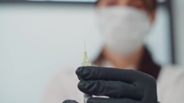 Yakından bir güzellik uzmanı şırıngaya basar, iğneden sıvı çıkar. Güzellik iğneleri ve kozmetolojide güzellik prosedürleri. Yüksek kalite 4k görüntü