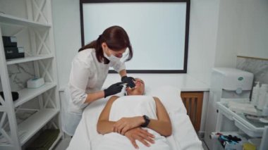 Bir kozmetikçi bir kadın üzerinde biyo-evrim işlemi gerçekleştirir. Kozmetik kliniğinde bir kızın cildini tazelemek için yapılan iğneler. Yüksek kalite 4k görüntü
