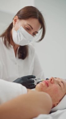 Bir kozmetoloji kliniğinde biyolojik evrim prosedürü. Bir kozmetikçi kaldırma ve gençleştirme için bir kadının yüzüne iğne yapar. Görünüş için güzellik ve sağlık hizmeti. Yüksek kalite 4k görüntü