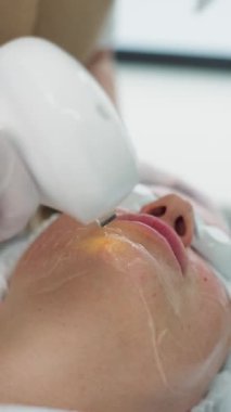 Bir kozmetoloji kliniğinde profesyonel donanım yüz temizleme prosedürü geçiren bir kadın. Parlak, pürüzsüz ve taze cilt için cilt bakımı. Yüksek kalite 4k görüntü