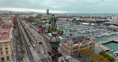 Placa de les Drassanes, Barcelona 'nın insansız hava aracı görüntüleri: Rıhtımda trafik, limanda demirlemiş tekneler ve Katalonya' nın çarpıcı sahil manzarası. Yüksek kalite 4k görüntü