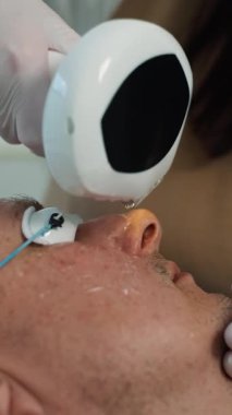 Erkek güzellik hizmetleri: son sınıf öğrencisi bir kozmetoloji kliniğinde derin bir cilt temizleme tedavisi görüyor. Yüz bakımı, cilt bakımı ve profesyonel güzellik prosedürleri. Yüksek kalite 4k görüntü