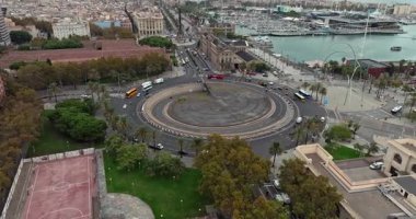 Yukarıdan Barcelona Placa de les Drassanes: Hareketli liman manzarası, karayolu trafiği, marinadaki botlar ve Katalonya 'daki canlı şehir hayatı. Yüksek kalite 4k görüntü