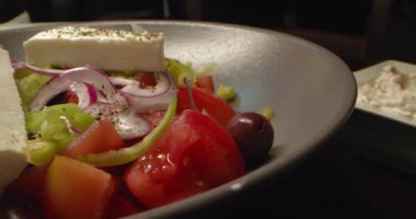 Restoran masasındaki tabakta Yunan salatasının içeriği. Lezzetli, besleyici sebzeler, yeşiller ve peynir. Yüksek kalite 4k görüntü