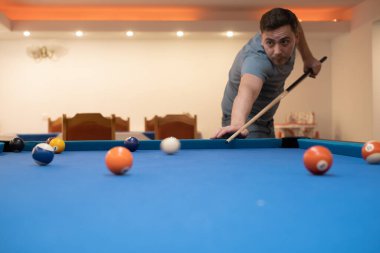 a man holds his hand on a pool table, plays snooker or prepares to shoot billiard balls, port game snooker billiards, billiard balls, play billiards