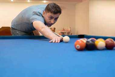 a man holds his hand on a pool table, plays snooker or prepares to shoot billiard balls, port game snooker billiards, billiard balls, play billiards