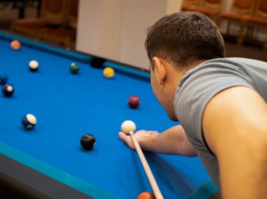 a man holds his hand on a pool table, plays snooker or prepares to shoot billiard balls, port game snooker billiards, billiard balls, play billiards