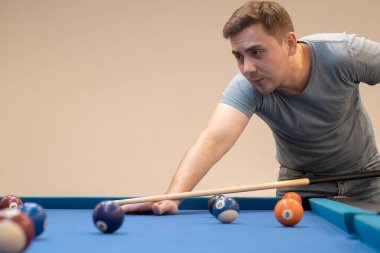 a man holds his hand on a pool table, plays snooker or prepares to shoot billiard balls, port game snooker billiards, billiard balls, play billiards