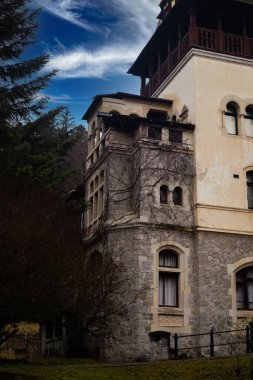 ancient building with a red roof in the forest of romania evening time