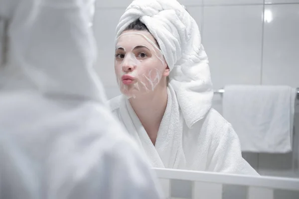 Young Caucasian Woman White Bathrobe Towel Her Head Removes Moisturizing — Zdjęcie stockowe