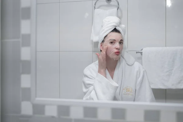 Young Caucasian Woman White Bathrobe Towel Her Head Removes Moisturizing — Stock fotografie