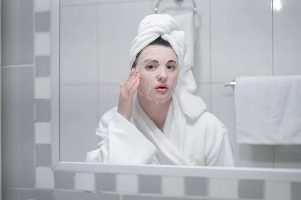 Young Caucasian Woman White Bathrobe Towel Her Head Removes Moisturizing — Zdjęcie stockowe