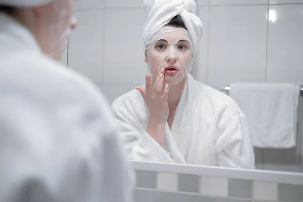 Young Caucasian Woman White Bathrobe Towel Her Head Removes Moisturizing — Stockfoto