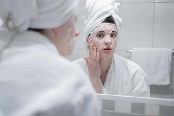 Young Caucasian Woman White Bathrobe Towel Her Head Removes Moisturizing — Stockfoto