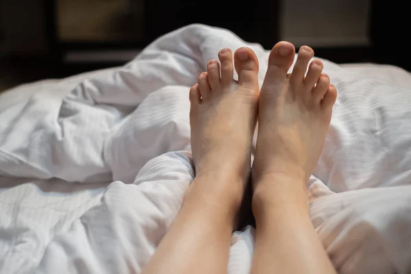 Дві Ноги Красивої Дівчини Білому Ліжку Частина Ніг Дівчини Виступає — стокове фото