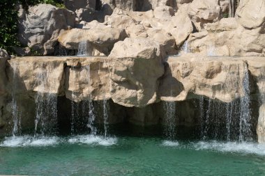 A small waterfall over the rocks and among the vegetation of the park