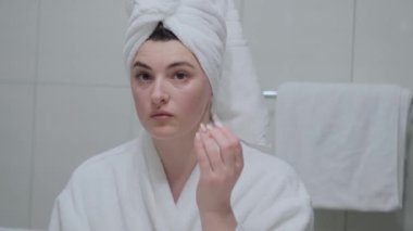 Yakın plan kadın krem alır, kavanozdan nemlendirici losyon sürer, ellerine nemlendirici sürer..