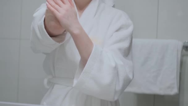 Dziewczyna Rozmazała Ręce Kremem Masowała Ubrana Biały Szlafrok Łazienkę Pielęgnację — Wideo stockowe