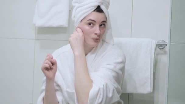 一个穿着浴衣的女人照着镜子 给自己做了面部按摩 用你的指尖触摸皮肤 在家里享受简单有效的抗皱治疗 除灭和预防灭蚁灵 — 图库视频影像