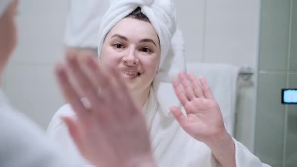 快乐的自由职业者欢迎密切关注我们的家 快乐的女孩在浴室里打了一个视频电话 在虚拟对话中 穿着浴衣的积极女性向同事挥手聊天 — 图库视频影像