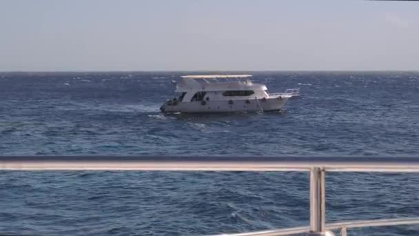 在阳光灿烂的日子里 一艘白色的大游艇在蓝色的海面上航行 一艘豪华游艇离开船坞的侧视图 在红海上的埃及游轮 游艇上的假日假期 — 图库视频影像