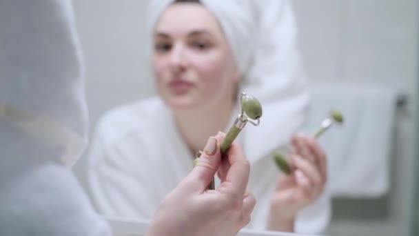 Menina Faz Uma Massagem Facial Com Rolo Jade Está Banheiro — Vídeo de Stock