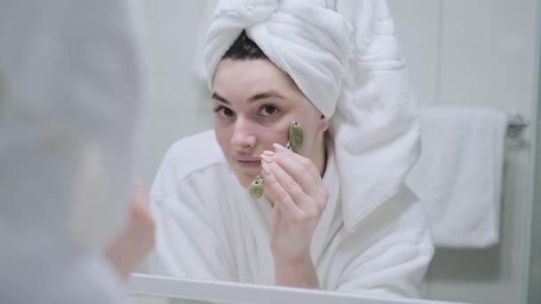 Dívka Dělá Masáž Obličeje Nefritovým Válečkem Koupelně Oblečená Bílém Županu — Stock video