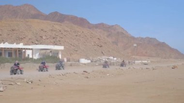 Mısır 'ın Sharm el Sheikh yakınlarındaki çölde bisiklet sürmek. ATVSand ve Sand Borkhan' daki çöl off-road maceraları. Kaya ve gün batımı. Dörtlü Bisiklet Seyahati. İnsanlarla Gezinti.