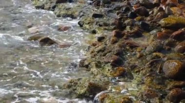 Deniz fırtınası, deniz dalgaları kıyı şeridindeki kayalıklarda patlıyor. Deniz sörfü, deniz sahili, sarı kum ve kayalık taşların patlamasına neden oluyor.