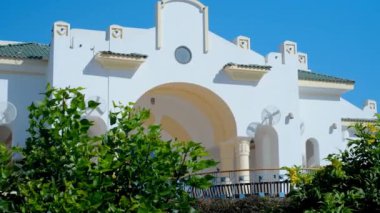 Güneşli bir günde palmiye ağaçları olan doğulu meçhul evler, zaman aşımı, Mısır 'da bir otel binasının güzel beyaz mimarisi.