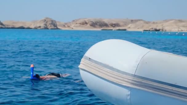 Ein Mädchen Einer Maske Schnorchelt Meer Ein Schlauchboot Liegt Der — Stockvideo