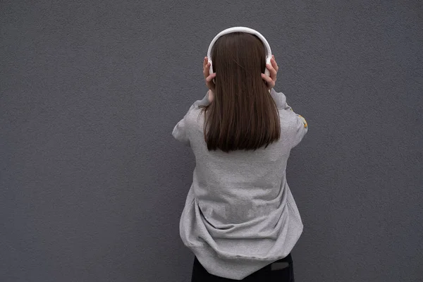 Uma Linda Garota Fica Costas Fones Ouvido Olha Para Distância — Fotografia de Stock
