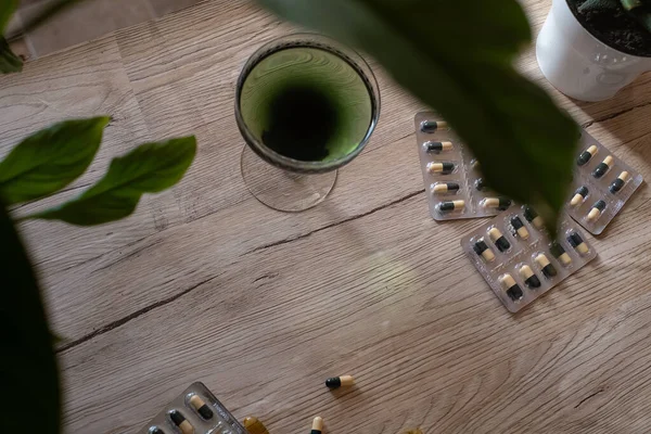クロロフィル抽出物は 緑色の葉を持つ木製の背景にガラス中のきれいな水に注ぎ込まれます 水のガラス中の液体クロロフィル スーパーフード 健康的な食事 デトックスと食事の概念 — ストック写真