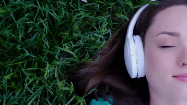 Een Meisje Luistert Naar Muziek Koptelefoon Zomer Een Weide Een — Stockvideo