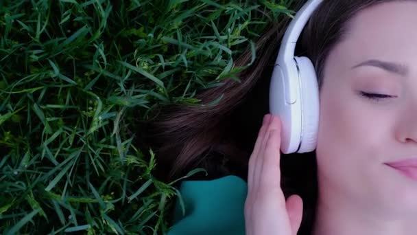 Een Meisje Luistert Naar Muziek Koptelefoon Zomer Een Weide Een — Stockvideo