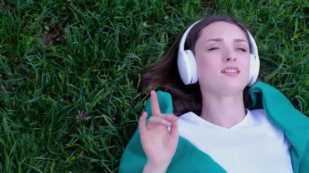 Entspannte Frau Liegt Gras Und Hört Musik Mit Kopfhörern Einem — Stockvideo