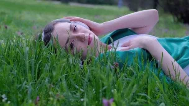 Avslappnad Kvinna Liggande Gräset Lyssnar Musik Med Hörlurar Park — Stockvideo