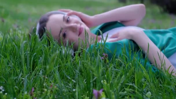 Avslappnad Kvinna Liggande Gräset Lyssnar Musik Med Hörlurar Park — Stockvideo