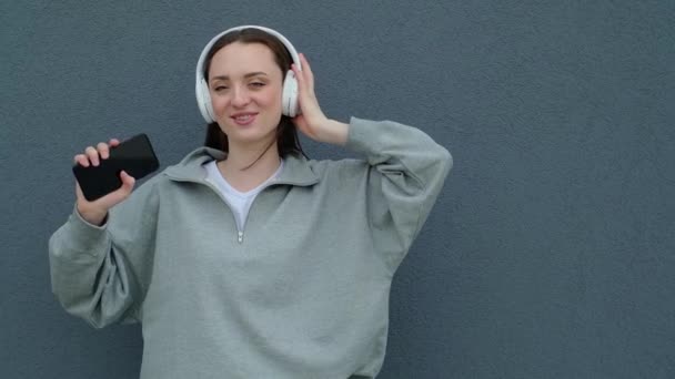 ヘッドフォンの笑顔の10代の女の子に沿って歌う スローモーション — ストック動画