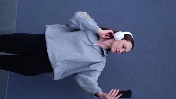 Kulaklıklı Gri Arka Planda Izole Edilmiş Cep Telefonuyla Selfie Çeken — Stok video
