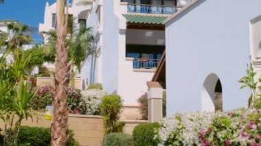 Beyazlı otel. Bahçe manzarası, havuz ve tropik palmiye ağaçları
