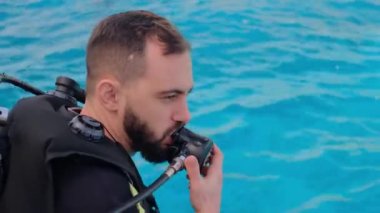 Tüple dalış yapan bir adam bir yatta oturuyor, dalmaya hazırlanıyor, denize dalıyor, bir eğitmen tüplü dalış yapmayı öğretiyor, dalmayı öğrenme süreci....