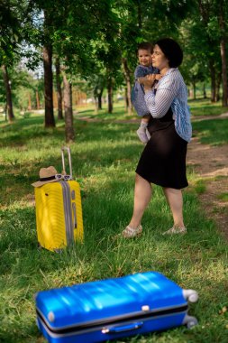 Anne ve kızı yolculuk için hazırlanıyorlar. Küçük bir kız sarı bir bavula oturur. Seyahate çık, denizde rahatla, tatilde semodan topla.