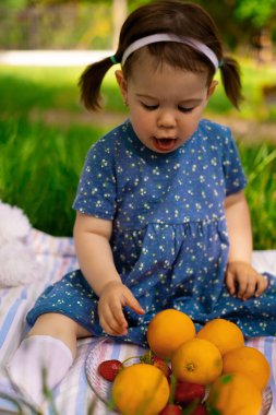 Yazın dışarıda portakal yiyen mutlu bir çocuğun portresi piknik, doğa, yaşam tarzı, aile günü, izin günü.