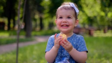 Küçük tatlı kız palsin yer, portakal suyu ellerinden akar, vitamin tüketimi, portakal suyu, çocuklar için vitaminler.